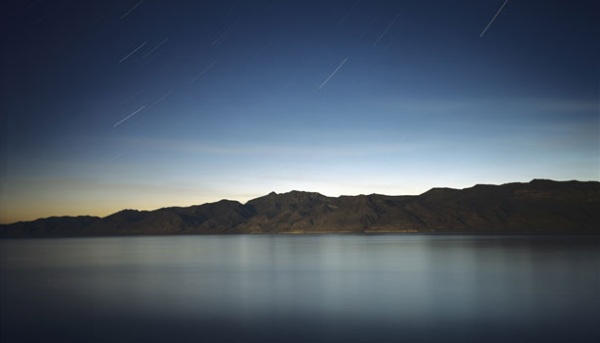 Photo de fond d'écran de l'iPad. Prise par Richard Misrach, lac pyramide, affiche une trainée d'étoiles car la photo a été prise de nuit en longue pose.